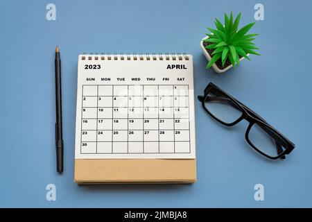 Tischkalender April 2023 auf blauem Hintergrund. Direkt darüber. Stockfoto