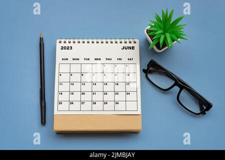 Tischkalender Juni 2023 auf blauem Hintergrund. Direkt darüber. Stockfoto