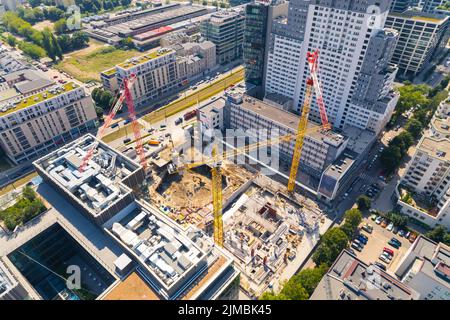 Professionelle Baustelle mit mehreren Kranen, die an einem Gebäudekomplex arbeiten. Zukünftige Wohnungen im Prozess des Baus. Hochwertige Fotos Stockfoto