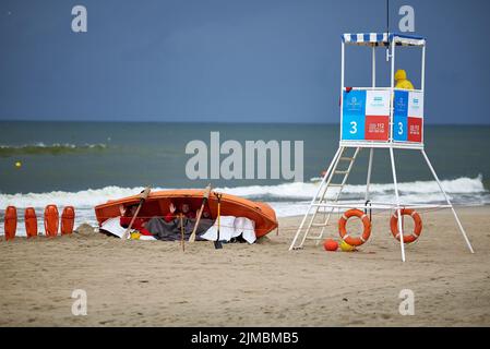 Rettungsschwimmer verstecken sich während eines Sturms am Strand im Rettungsboot Stockfoto