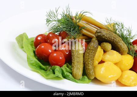Verschiedene Gemüsesorten auf weißem Teller. Eingelegte Gurken Stockfoto