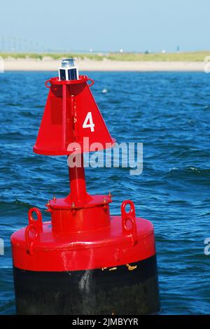 Red Boje 4 bohrt im Wasser der Bucht und markiert an einem sonnigen Sommertag den Kanal und die Bootswege in den Hafen Stockfoto