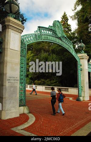 Zwei Studenten gehen durch die historischen Sather Gates, die zum Campus der University of California Berkeley (Cal) in der Bay Area führen Stockfoto