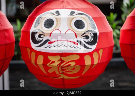 Daruma-Puppen. Die japanischen glücklichen symbolischen Puppen hängen in der Reihe mit Textübersetzung â € œfortuneâ €. Stockfoto