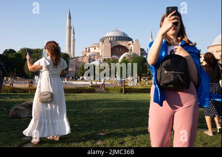 Istanbul, Türkei. 01.. Juli 2022. Touristen stehen mit Smartphones im Sultanahmet Park vor der Hagia Sophia Kirche. Quelle: Sebastian Kahnert/dpa/Alamy Live News Stockfoto