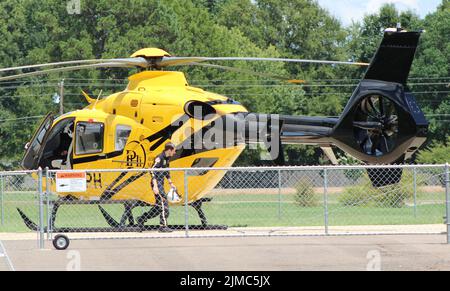 Columbus, MS USA August 5. 2022: Garrett Lyde, aus Meridian, MS, verlässt den Airbus EC 135-Hubschrauber von PHI Air Medical, nachdem er von einem abgesagten Flug zurückkehrte. „Wir haben auf 3 Anrufe reagiert, aber sie wurden abgesagt“, sagte Tanner Stewart von New Hope, Mississippi. Stewart fuhr fort und fügt hinzu: „Wir holen unseren nächsten Kraftstoff aus West Point, Mississippi und aus Lousiville, Mississippi, aber wir sind dabei, einen Tanker in Lowndes County zu bekommen. Das wird uns dabei helfen, schneller Kraftstoff zu tanken.“ Der Hubschrauber und seine Besatzung sind in der Freiwilligen Feuerwehr des Distrikts 3 im Lowndes County, Mississippi, stationiert. Cred Stockfoto