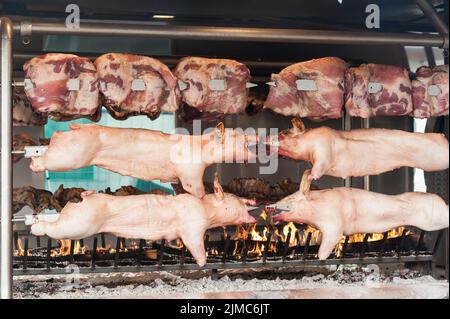 Schlachtkörper von Schweinefleisch und anderen Fleisch am Spieß. Stockfoto