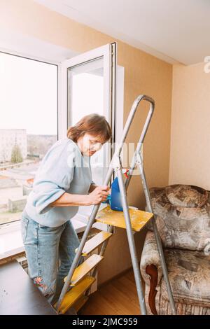 Glücklich Schüchtern Reifen Frau Reinigung Haus. Konzept Von Haushalt Und Menschen Im Ruhestand. Ältere Frau Reinigung Apartment. Unabhängige Ältere Frau Ein Stockfoto