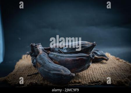 Schwarzer verfauler Bananenkamm auf einem Sackhintergrund Stockfoto