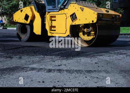 Straßenroller in Wohngegend, Asphaltstraßensanierung im Sommer Stockfoto