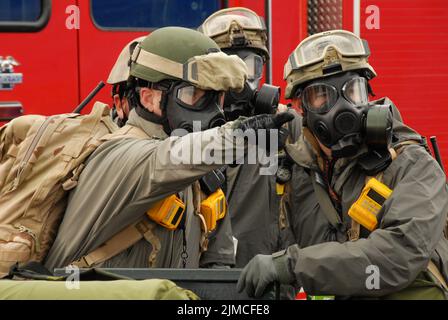 Mitglieder der US Air Force 304. RQS von der Portland Air National Guard Base schauen in das Gebiet, in das sie einreisen werden, um verletzte Zivilisten nach einer simulierten Explosion schmutziger Bomben auf dem Portland International Raceway während des TOPOFF 4 am 16. Oktober 2007 zu Bergen. (Foto DER US-Luftwaffe von Senior Airman John Hughel, 142. Fighter Wing Public Affairs) Stockfoto