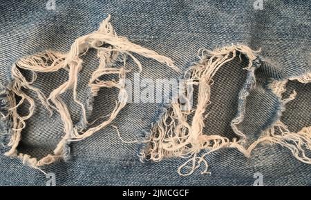 Zerrissene Jeans im Hintergrund. Textur aus Denim oder blauem Jeans Hintergrund. Stockfoto