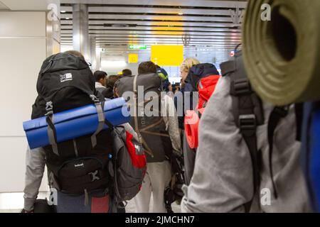 Rucksacktouristen, die zu Beginn einer Expedition durch einen Flughafen laufen Stockfoto