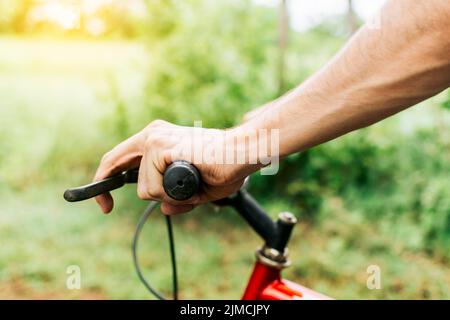 Seitenansicht der Hände am Fahrradlenker, Nahaufnahme der Hände am Fahrradlenker. Konzept des Radfahrers Hände auf den Lenker Stockfoto