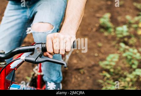 Seitenansicht der Hände am Fahrradlenker mit Kopierraum. Konzept des Radfahrers Hände am Lenker, Nahaufnahme der Hände am Fahrradlenker Stockfoto