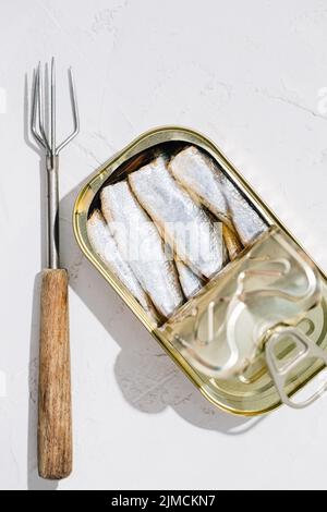 Draufsicht auf eine in zwei Hälften geöffnete Dose Sardinen auf weißem Hintergrund Stockfoto