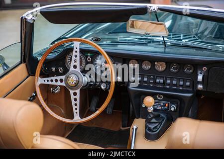 Blick in den Innenraum des Linkslenkers englischer historischer Sportwagen-Oldtimer-Roadster Jaguar E E-Type mit Lenkrad und Armaturenbrett Stockfoto