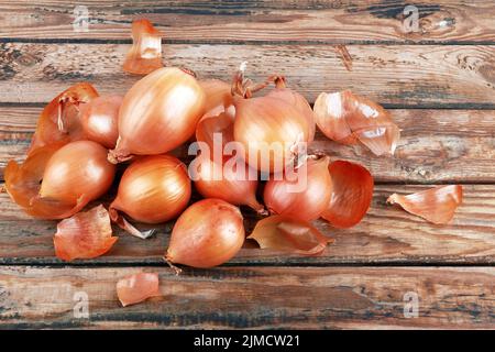 Reife frische goldene Zwiebeln auf einem hölzernen Hintergrund Stockfoto