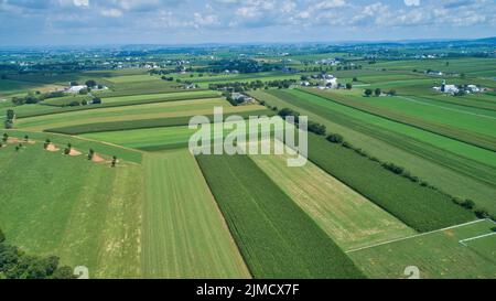 Luftaufnahme von Bauernhöfen im Sommer mit blauem Himmel Und weiße, flauschige Wolken Stockfoto