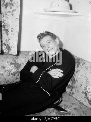 Um 1965, London, England, Großbritannien: Der amerikanische Schauspieler DANNY KAYE sitzt auf einer Blumencouch und trägt einen Morgenmantel. (Bild: © Keystone USA/ZUMA Press Wire) Stockfoto