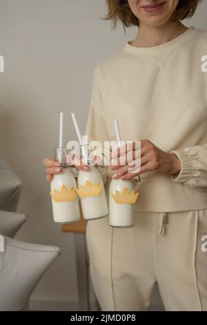 Eine nicht erkennbare Frau mit einem Milchshake in einer Glasflasche auf einer Geburtstagsparty Stockfoto