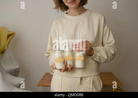 Eine nicht erkennbare Frau mit einem Milchshake in einer Glasflasche auf einer Geburtstagsparty Stockfoto