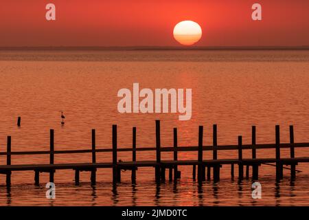 Die Sonne geht über der Mobile Bay unter, von Fairhope, Alabama aus gesehen. Stockfoto