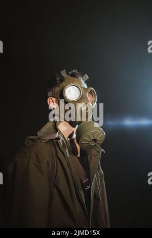 Nicht erkennbarer männlicher Entdecker in Gasmaske im dunklen unterirdischen Tunnel während der Apokalypse Stockfoto