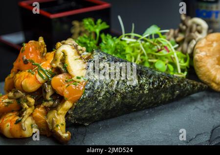 Temaki-Sushi. Traditionelle japanische Küche, Premium-Temaki mit Pilzen, Garnelen und Lachs, dekorieren Stockfoto