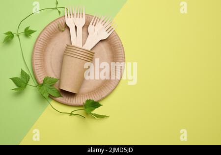 Braune runde Pappteller und Einwegbecher. Das Konzept der Vermeidung von Kunststoffschalen, die Umwelt schonen, flach legen Stockfoto