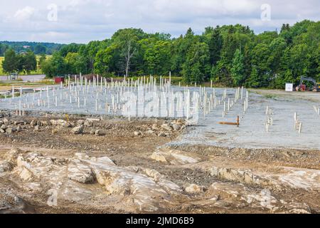 Blick auf das Industriegebiet mit Betonpfählen, die in den Boden getrieben wurden. Schweden. Stockfoto