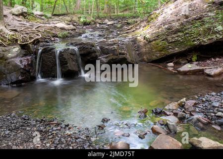 Langzeitbelichtung eines ätherischen Waldstroms und Wasserfalls mit Felsformation Stockfoto