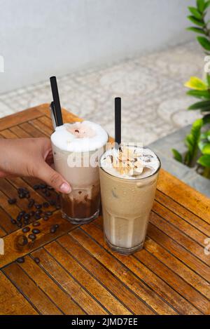 Die Hand der Frau hält Kaffeegetränke Stockfoto