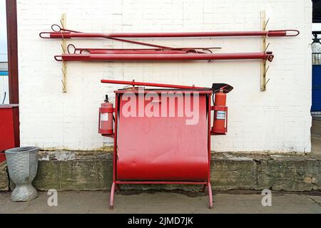 Feuerlöschgeräte stehen mit Sandkasten, Feuerlöscher, Pik und Feuerhaken Stockfoto