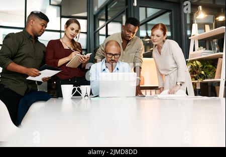 Eine effektive Strategieentwicklung nimmt dem Wachstum des Unternehmens das Rätselraten ab. Eine Gruppe von Geschäftsleuten, die während eines Meetings in einem modernen Büro einen Laptop verwenden. Stockfoto
