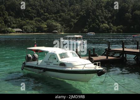 Ein Touristenboot auf dem Küstenwasser von Pulau Sapi (Sapi Insel), einem Teil des Tunku Abdul Rahman Parks in Sabah, Malaysia. Stockfoto