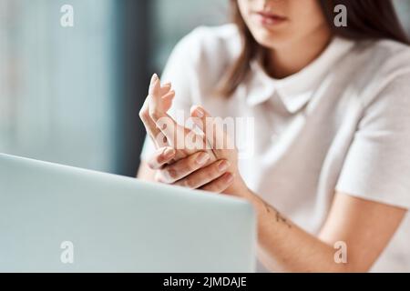 Spüren der Belastung der Sehnen ihrer Handgelenke und Hände. Nahaufnahme einer nicht erkennbaren Geschäftsfrau, die während der Aufnahme Unannehmlichkeiten in der Hand hatte Stockfoto