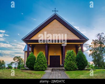 Alte Holzkirche bei Sonnenuntergang Wolken. Holzkirche Auf Dem Land Stockfoto