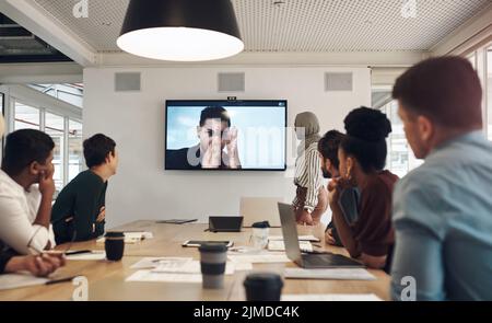 Eine Gruppe von Geschäftskollegen traf sich im Sitzungssaal zu einer Videokonferenz. Stockfoto