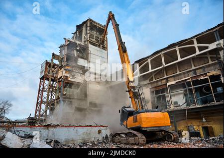 Abriss eines verlassenen Industriegebäudes durch Bagger Stockfoto