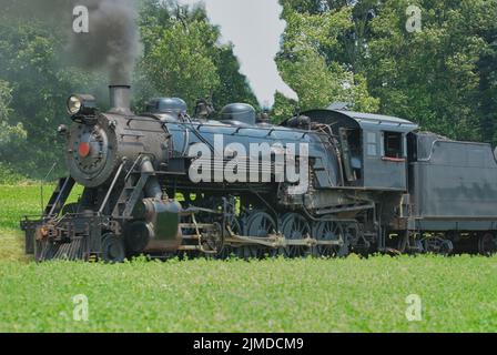 Nahaufnahme eines antiken Dampfeisenbahnzuges, der sich entlang stampft Stockfoto