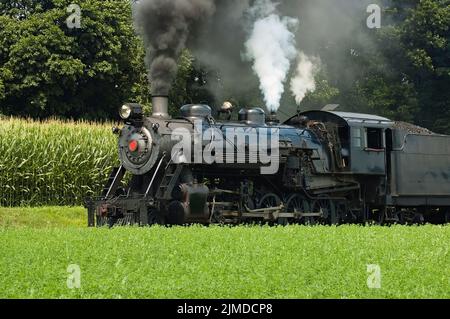 Dampfzug mit Passagierzug durch die Landschaft der Amish Stockfoto