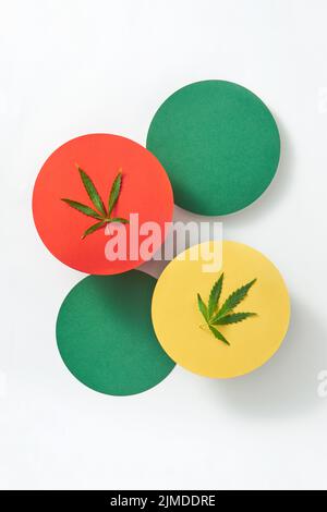 Bunte runde Karten mit Marihuana-Blättern auf hellgrauem Hintergrund. Stockfoto