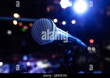 Mikrofonkörper auf der Bühne während eines Konzerts mit bunten Lichtern im Hintergrund Stockfoto