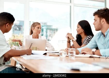 Eine Gruppe junger Geschäftskollegen, die während eines Meetings im Sitzungssaal sitzen. Stockfoto