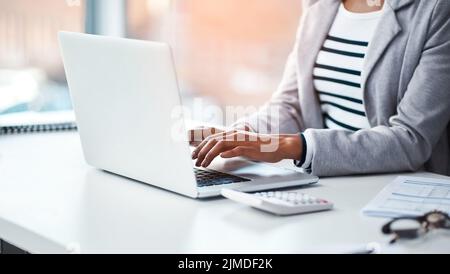 Buchhalterin tippt in ihrem Büro auf einem Laptop oder recherchiert im Internet, während sie an einem Schreibtisch sitzt. Nahaufnahme eines Finanzberaters, der arbeitet Stockfoto