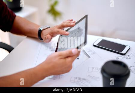 Etwas Neues zu entwerfen. Nahaufnahme eines nicht erkennbaren Architekten, der ein digitales Tablet in einem Büro verwendet. Stockfoto