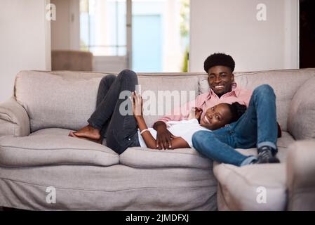 Wir lieben einen guten Tag der Entspannung. Ein glückliches junges Paar, das sich zu Hause auf dem Sofa entspannt. Stockfoto