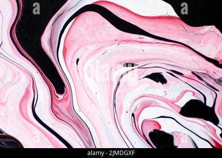 Marmoriertes Acrylfarbenmuster in den Farben rot, schwarz, weiß und pink. Stockfoto