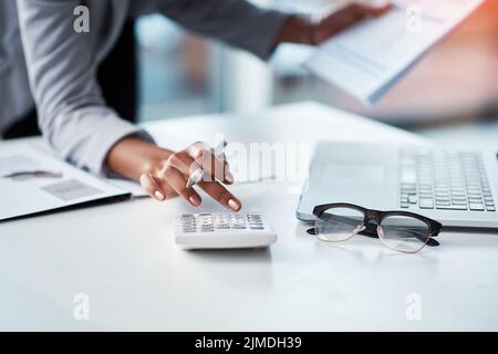 Buchhalterin, Geschäftsfrau oder Bankkauffrau, die Taschenrechner verwendet, prüft Papierkram und Dokumente, während sie in einem Büro Finanzdatenberichte erstellt. Hände eines Stockfoto